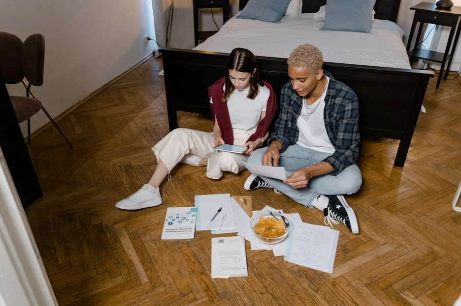 Студентка с улыбкой работает за ноутбуком в кампусе